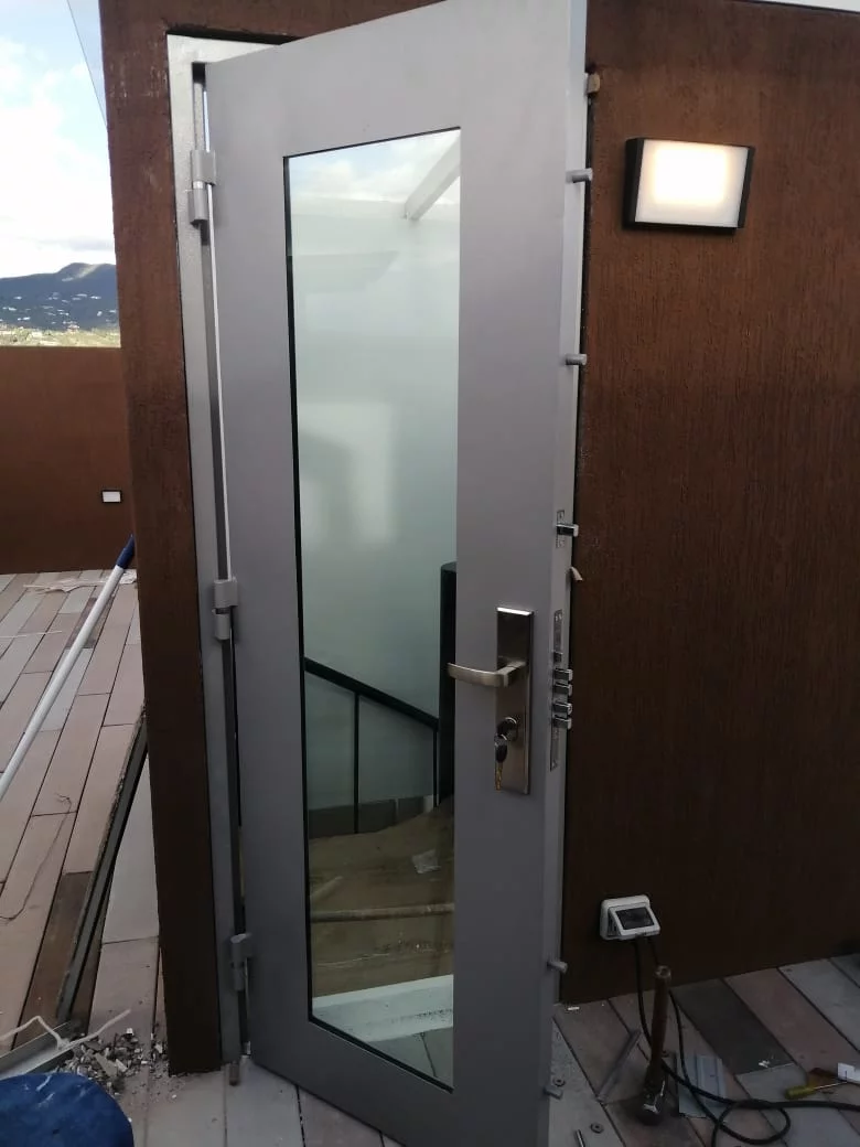 Puerta blindada de seguridad con acabado en madera instalada en Bogotá