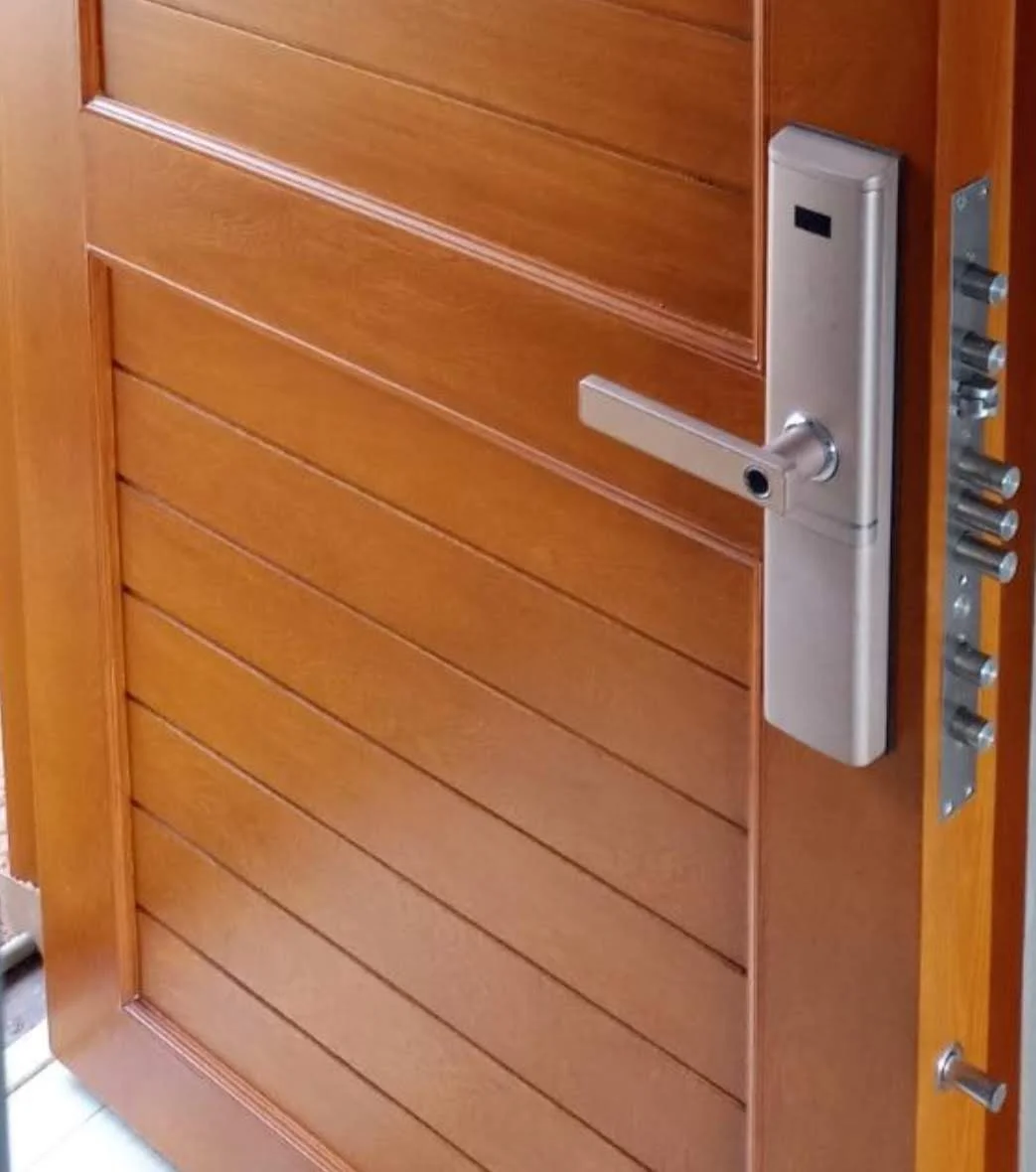Puerta de seguridad en madera con cerradura multipunto y pivotes antipalanca visibles, Bogotá