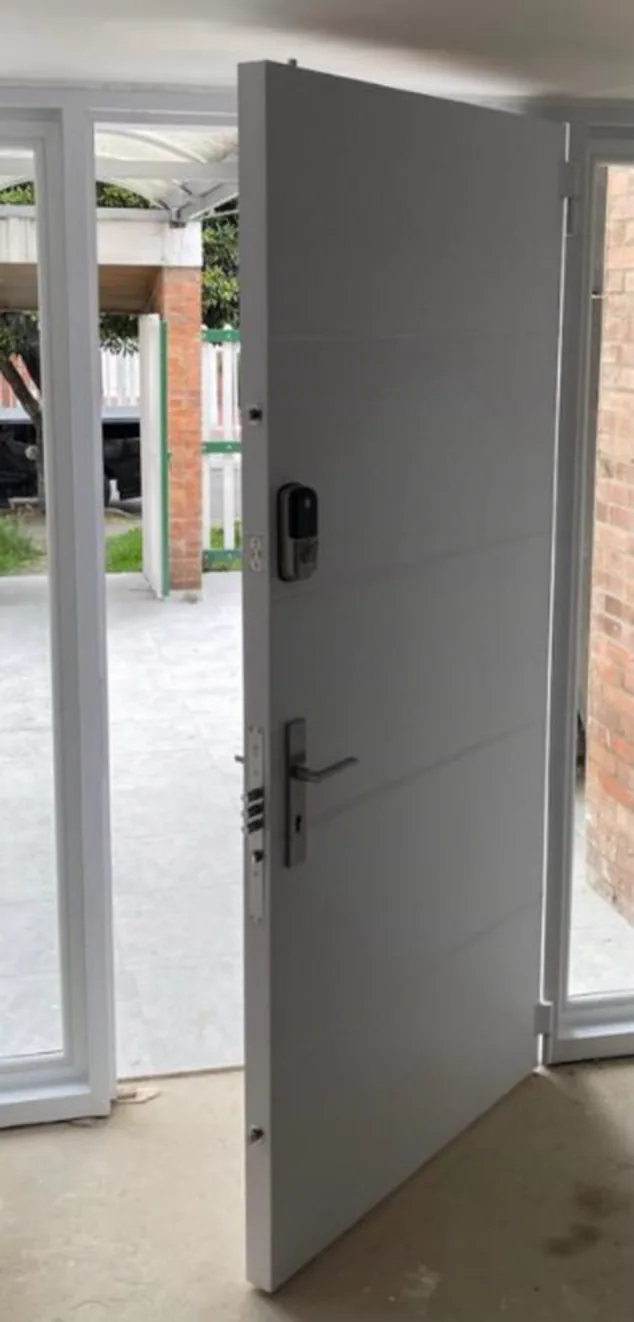 Puerta de seguridad blanca con sistema antipalanca instalada en casa de Ibagué