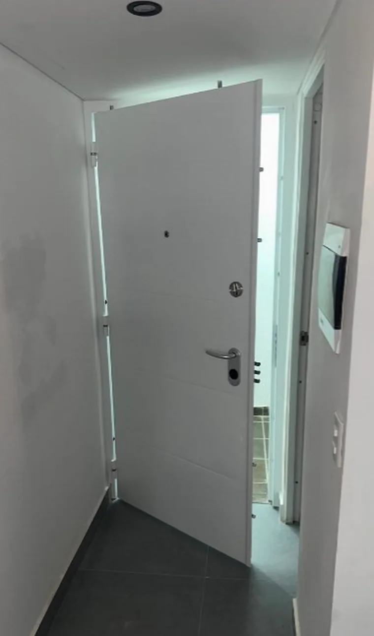 Puerta de seguridad blanca abierta recién instalada en apartamento de Ibagué