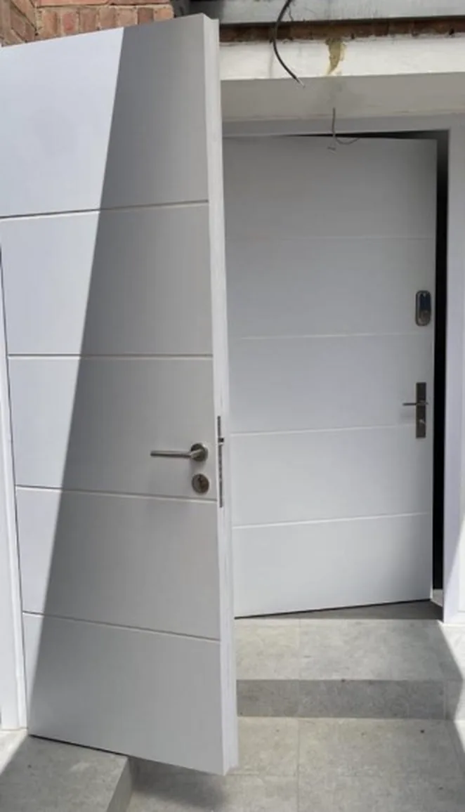 Puerta de seguridad blanca ranurada para apartamento, instalada en Ibagué