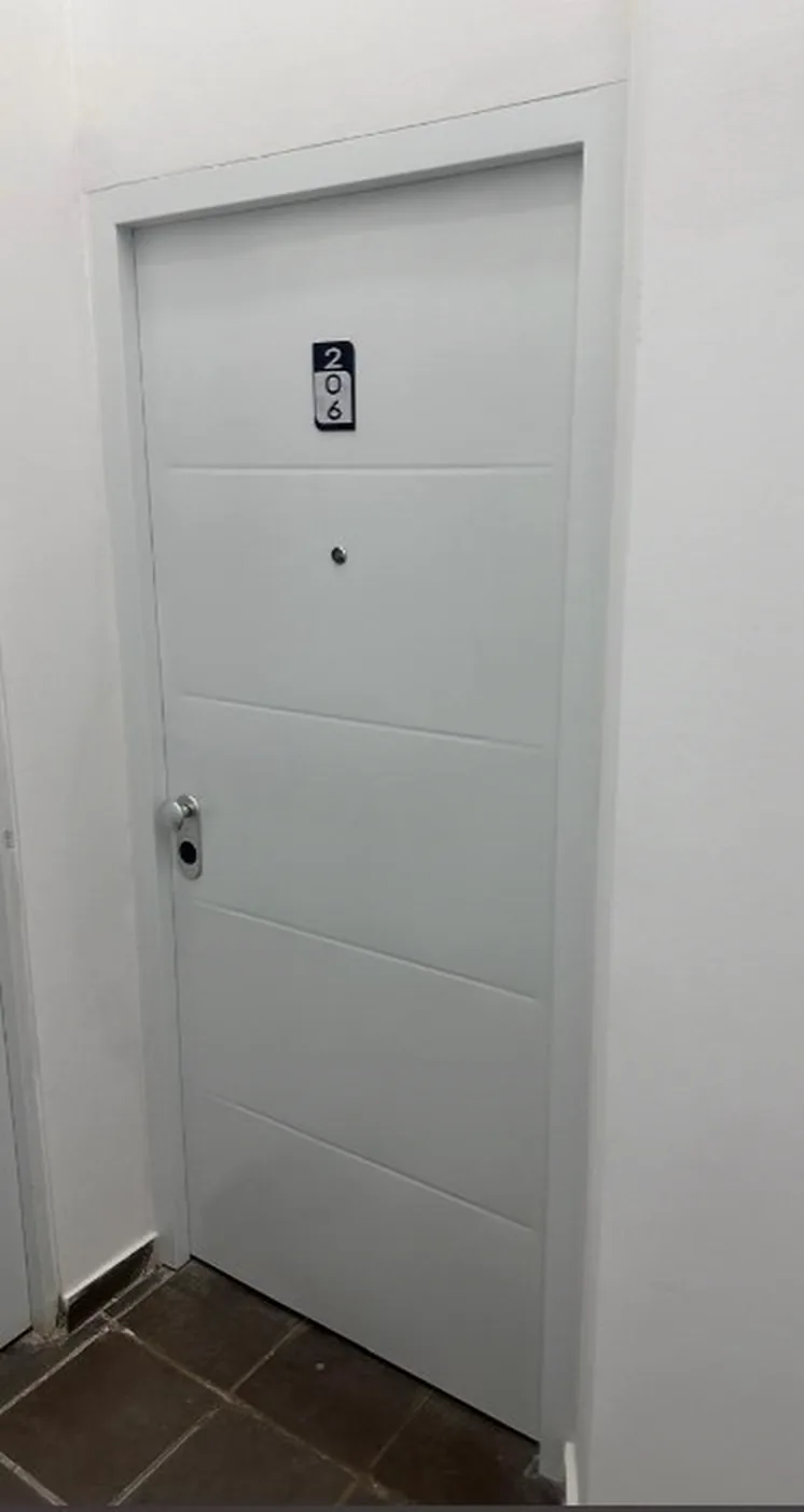 Puerta de seguridad blanca ranurada en conjunto residencial de Ibagué