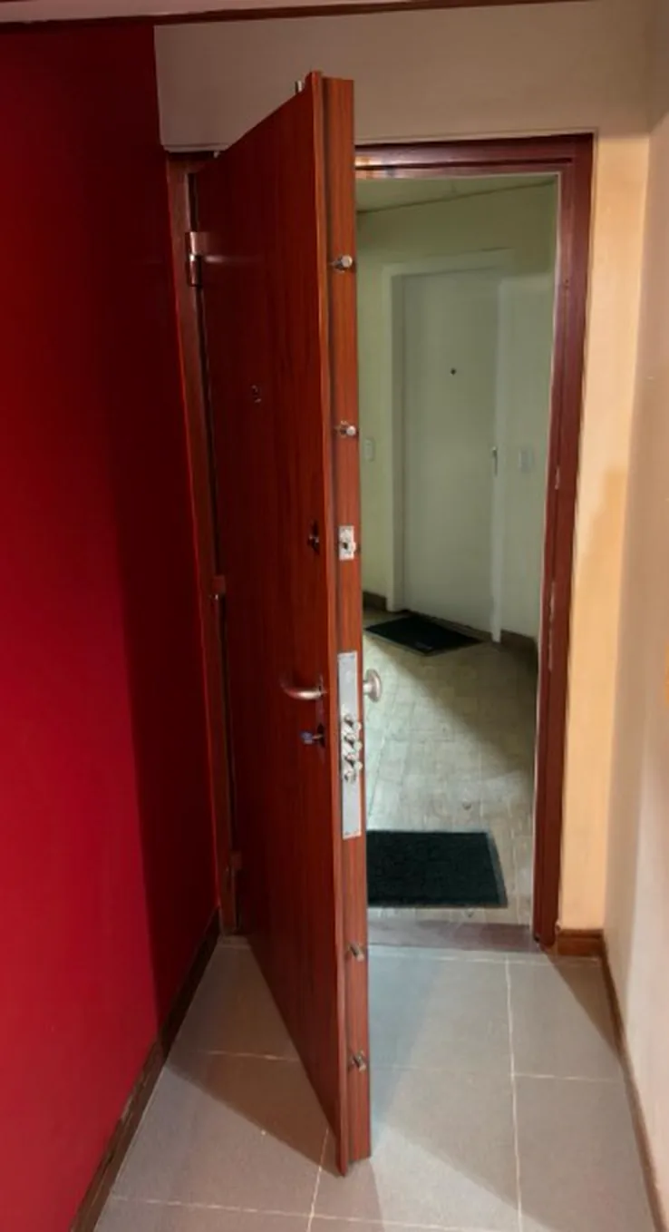 Puerta de seguridad en caoba abierta mostrando bisagras y pivotes antipalanca, Ibagué