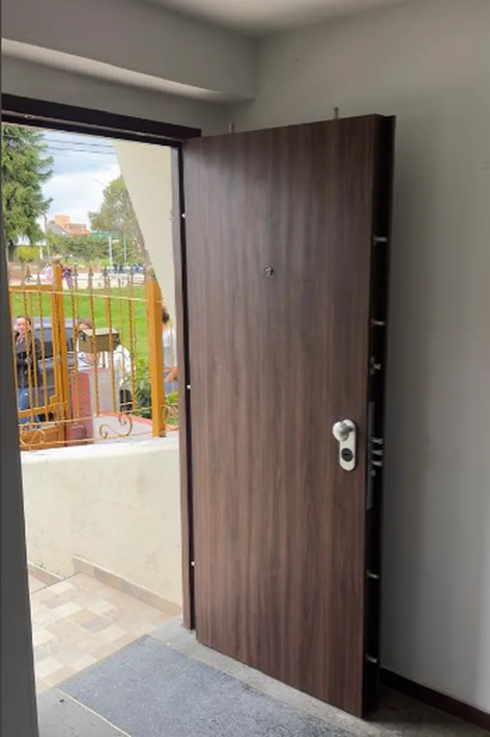 Puerta de seguridad en nogal abierta en la entrada de una casa en Ibagué