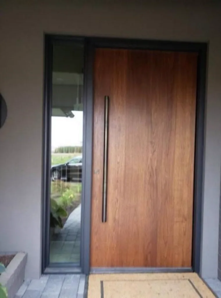 Puerta de seguridad en nogal con marco en aluminio y vitral lateral, instalada en Ibagué
