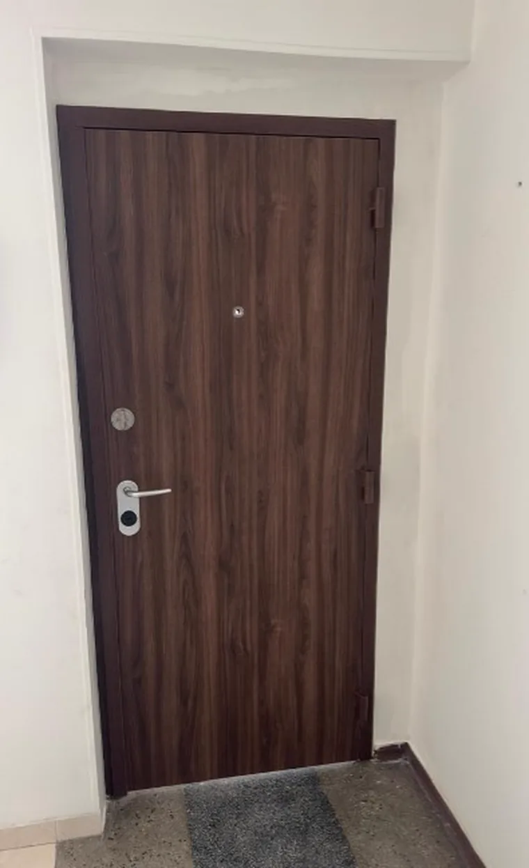 Puerta de seguridad en nogal oscuro con acabado mate instalada en apartamento de Ibagué